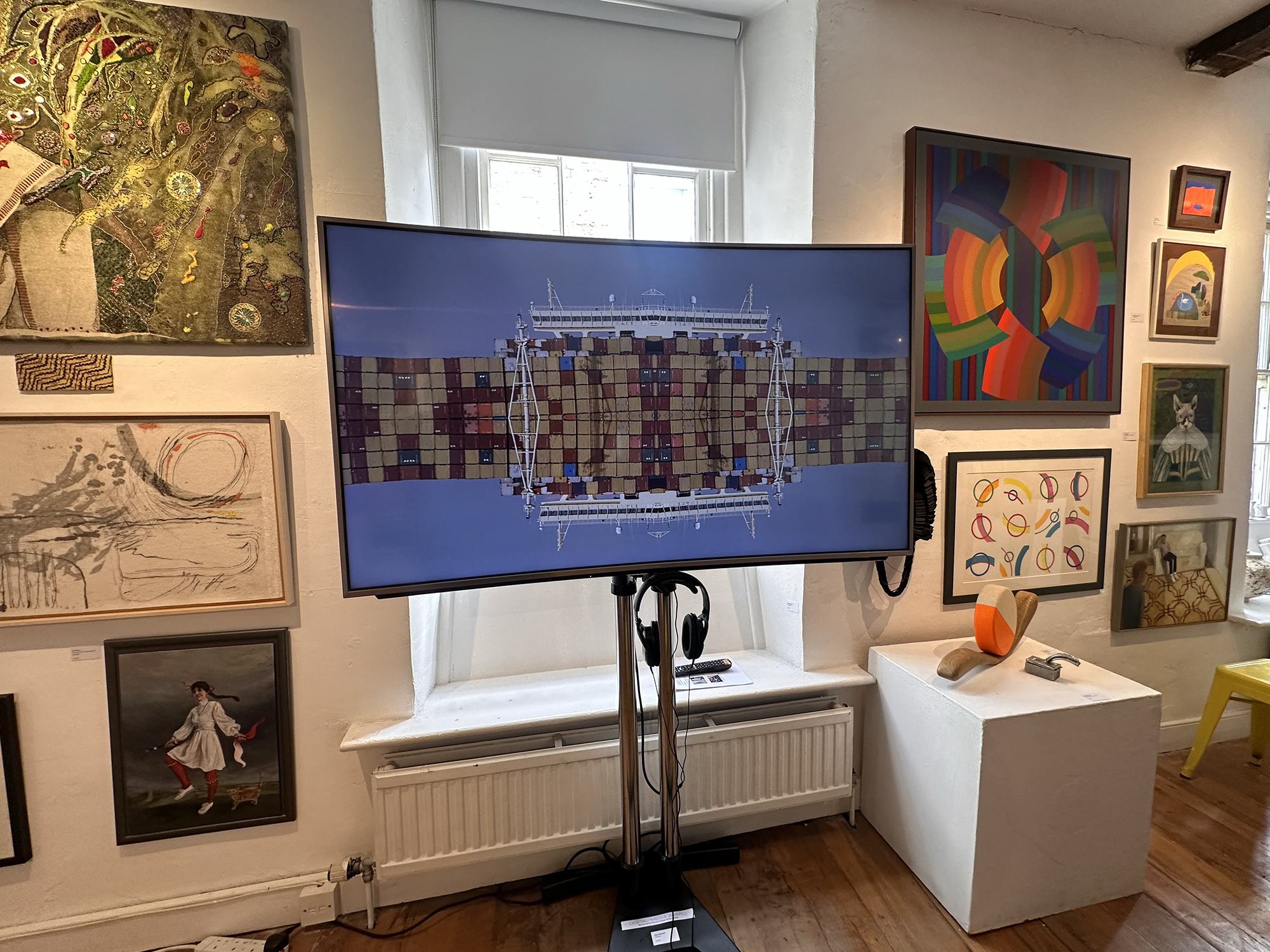 View of gallery wall with video artwork displayed on screen in foreground