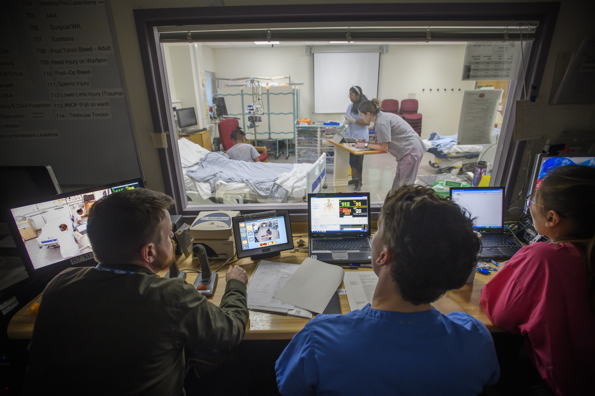 Teaching staff observing students in medical simulation suite