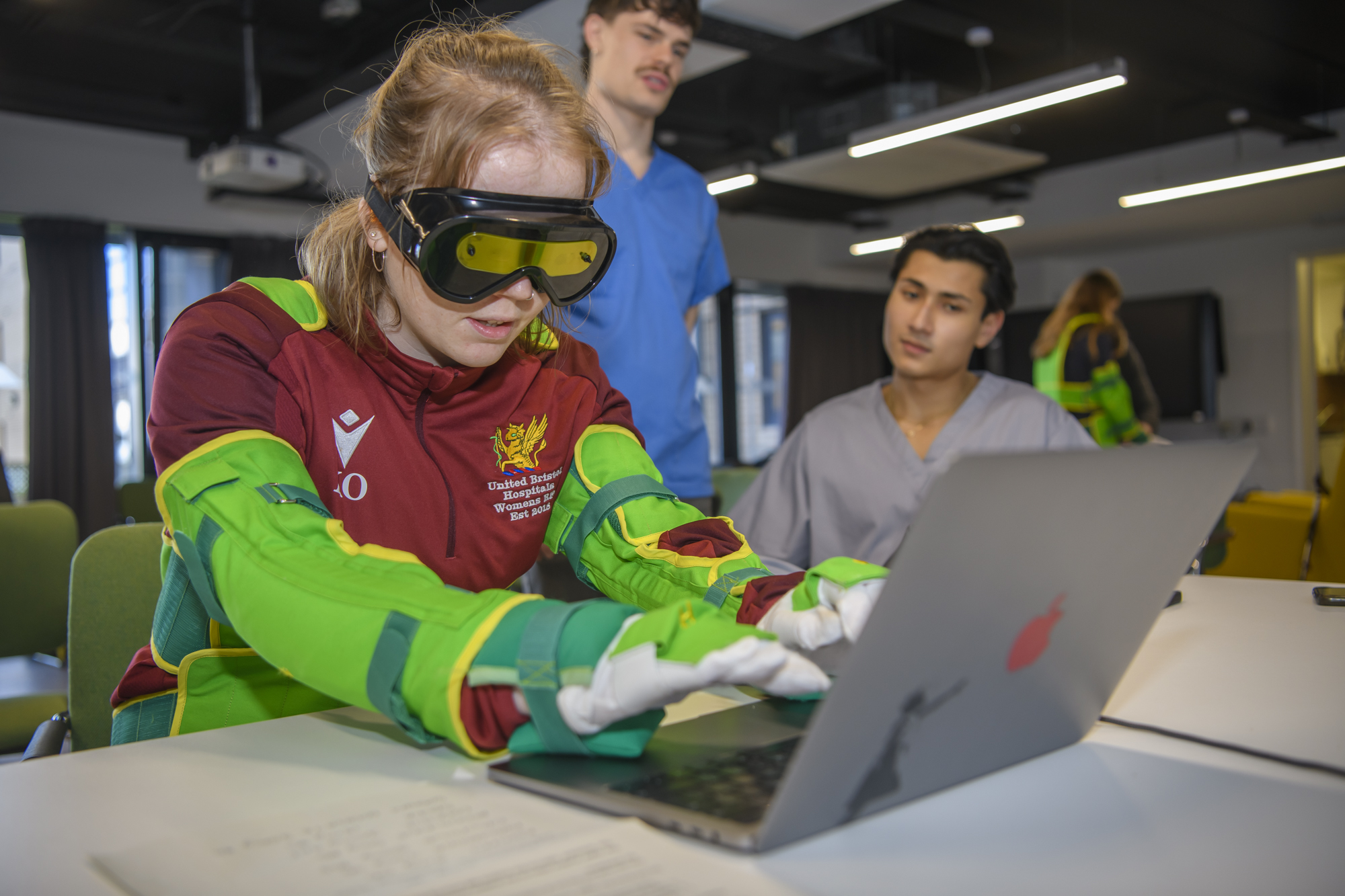 Students wearing apparatus to simulate patient's symptoms